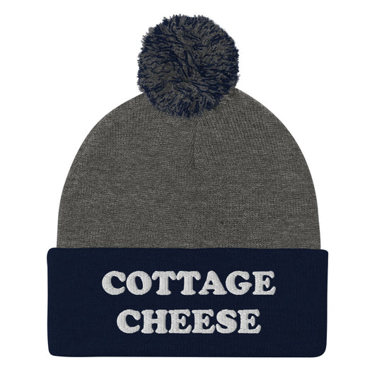 Gray and Blue cottage cheese beanie from Nina's Funky Shop - Do you love cottage cheese? Looking for a funny gift for a cottage cheese enthusiast? This warm and cozy, embroidered beanie is just what you need. It's a classic pom pom beanie with "cottage cheese", expertly embroidered on the front. The perfect funny beanie for everyday streetwear and foodies of all kinds.