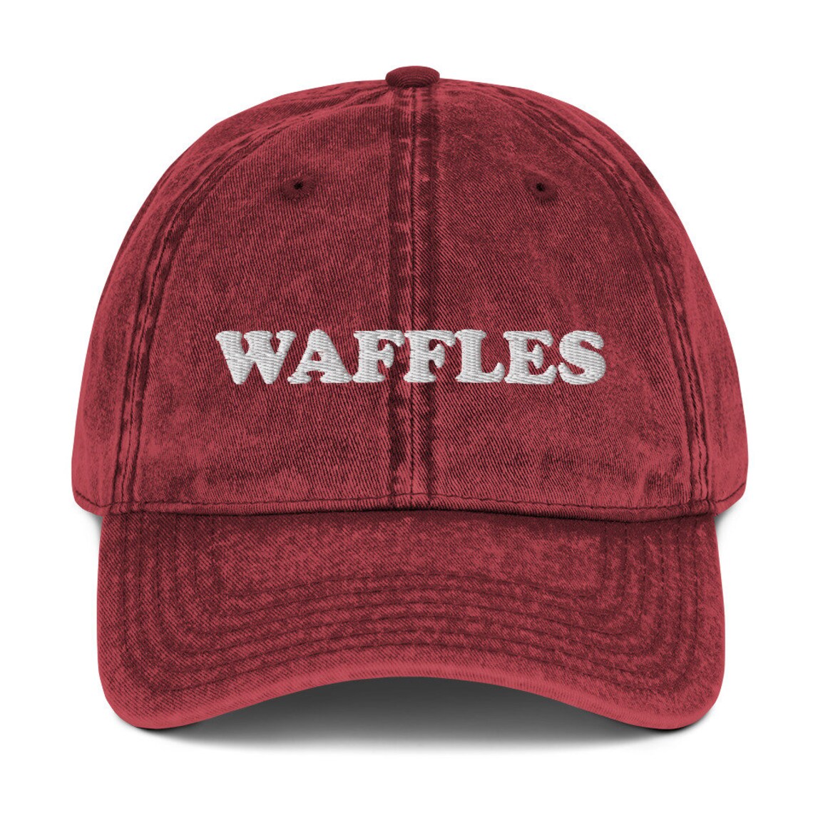 Washed out red denim dad hat for waffle lovers - The Waffles Dad Hat! This funny food dad hat is the perfect everyday accessory to show off your love of waffles. Wear the unique foodie dad hat for any occasion or give it as a stylish weird gift for a waffle lover. Show off your love of waffles and favorite foods in our vintage style weird dad hats and clothing. 