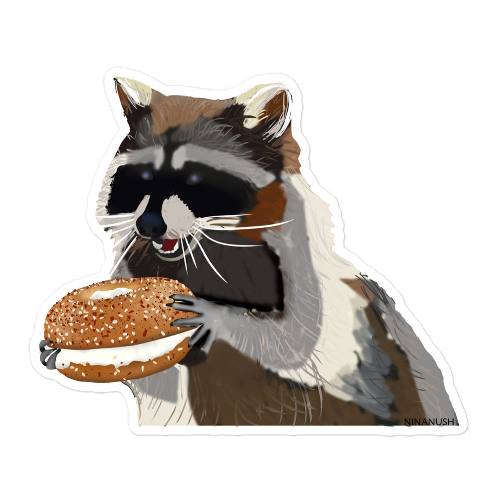 5.5x5.5 raccoon with a bagel sticker from Nina's Funky Shop by ninanush - The raccoon bagel Vinyl Sticker! Designed for raccoon enthusiasts and bagel lovers, this unique sticker features a naughty raccoon with a bagel. It's a hand drawn design by Nina and it's made just for you. This funky raccoon sticker is the perfect quirky addition to your sticker collection or gift for a raccoon lover. 