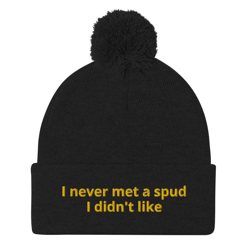 Black I Never Met A Spud I Didn't Like Dolly Beanie - Do you love potatoes? Looking for a funny gift for a potato enthusiast? This warm and cozy, embroidered beanie is just what you need. It's a classic pom pom beanie with "I never met a spud I didn't like", expertly embroidered on the front. The perfect funny beanie for everyday foodies and potato lovers of all kinds. 