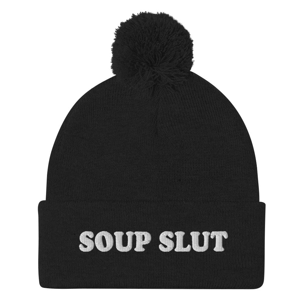 Black Embroidered Beanie with Soup Slut from Nina's Funky Shop - Love soup? Looking for a funny gift for a soup enthusiast? This warm and cozy, embroidered beanie is just what you need. It's a classic pom pom beanie with "soup slut", expertly embroidered on the front. The perfect weird beanie hat for soup sluts and foodies of all kinds. Celebrate your favorite foods in our funky foodie apparel.