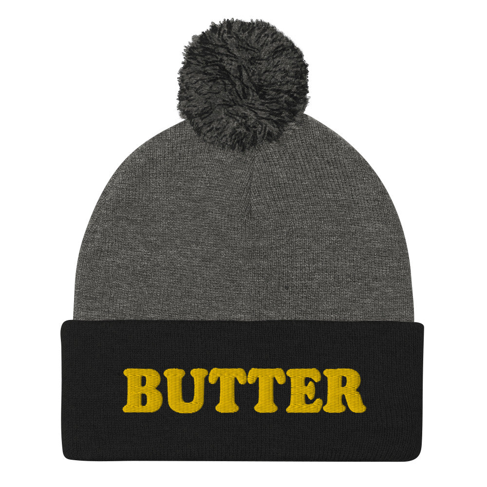 Gray and Black Butter Beanie - Do you love butter? Looking for a funny gift for a butter enthusiast? This warm and cozy, embroidered beanie is just what you need. It's a classic pom pom beanie with "butter", expertly embroidered on the front. The perfect funny beanie for butter lovers and foodies of all kinds. Celebrate your favorite foods in our funky foodie apparel.