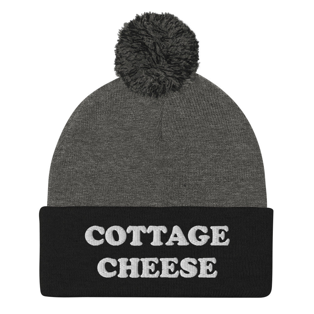 Black and gray cottage cheese beanie from Nina's Funky Shop - Do you love cottage cheese? Looking for a funny gift for a cottage cheese enthusiast? This warm and cozy, embroidered beanie is just what you need. It's a classic pom pom beanie with "cottage cheese", expertly embroidered on the front. The perfect funny beanie for everyday streetwear and foodies of all kinds.