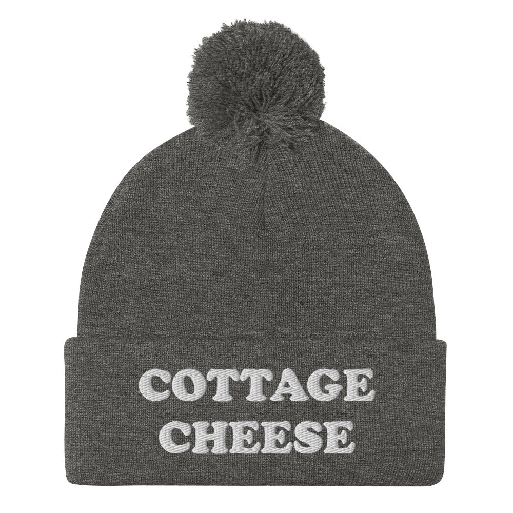 Gray cottage cheese beanie from Nina's Funky Shop - Do you love cottage cheese? Looking for a funny gift for a cottage cheese enthusiast? This warm and cozy, embroidered beanie is just what you need. It's a classic pom pom beanie with "cottage cheese", expertly embroidered on the front. The perfect funny beanie for everyday streetwear and foodies of all kinds.