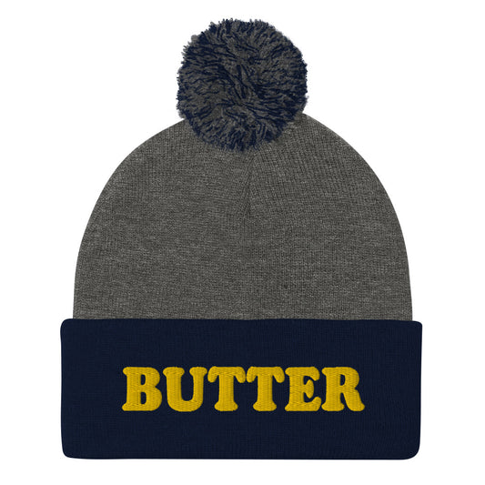 Gray and Navy Butter Beanie - Do you love butter? Looking for a funny gift for a butter enthusiast? This warm and cozy, embroidered beanie is just what you need. It's a classic pom pom beanie with "butter", expertly embroidered on the front. The perfect funny beanie for butter lovers and foodies of all kinds. Celebrate your favorite foods in our funky foodie apparel.