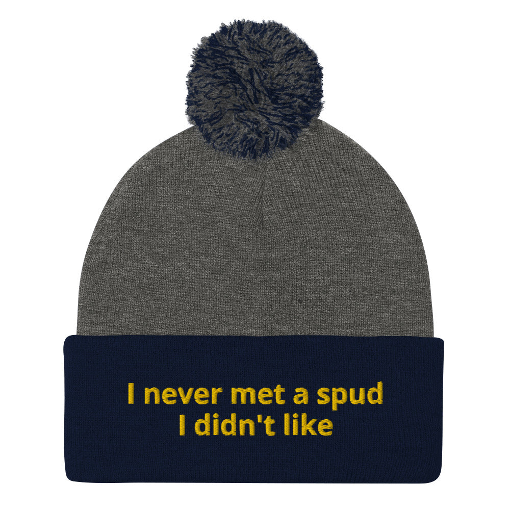 Navy and Gray I Never Met A Spud I Didn't Like Dolly Beanie - Do you love potatoes? Looking for a funny gift for a potato enthusiast? This warm and cozy, embroidered beanie is just what you need. It's a classic pom pom beanie with "I never met a spud I didn't like", expertly embroidered on the front. The perfect funny beanie for everyday foodies and potato lovers of all kinds.