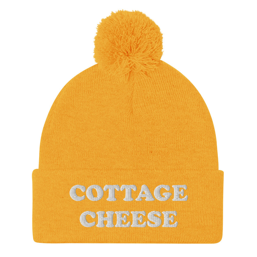 Yellow cottage cheese beanie from Nina's Funky Shop - Do you love cottage cheese? Looking for a funny gift for a cottage cheese enthusiast? This warm and cozy, embroidered beanie is just what you need. It's a classic pom pom beanie with "cottage cheese", expertly embroidered on the front. The perfect funny beanie for everyday streetwear and foodies of all kinds.