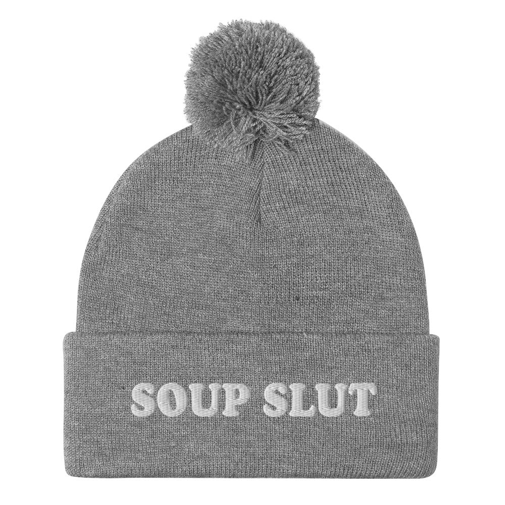 Gray Embroidered Beanie with Soup Slut from Nina's Funky Shop - Love soup? Looking for a funny gift for a soup enthusiast? This warm and cozy, embroidered beanie is just what you need. It's a classic pom pom beanie with "soup slut", expertly embroidered on the front. The perfect weird beanie hat for soup sluts and foodies of all kinds. Celebrate your favorite foods in our funky foodie apparel.