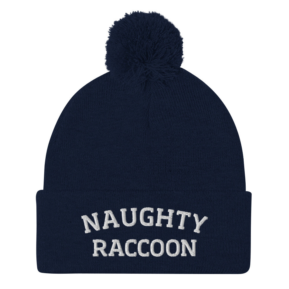 Navy naughty raccoon beanie from Nina's Funky Shop by ninanush - This Naughty Raccoon hat is warm, cozy, designed by Nina and made just for you. It's a comfortable unisex beanie with a pom pom on top, expertly embroidered with the words "naughty raccoon". The perfect weird beanie for raccoon enthusiasts and funny hat for quirky accessory lovers of all kinds.