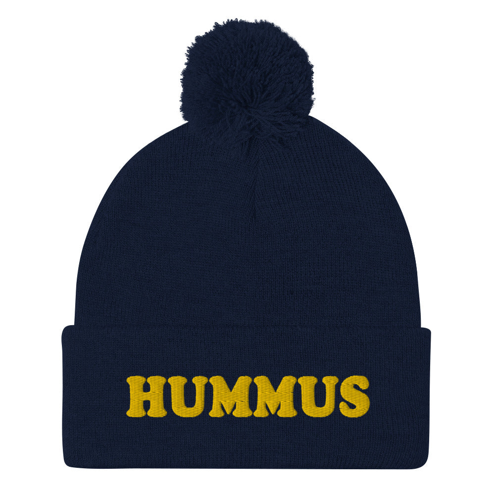 Navy Beanie with Hummus Embroidered on the front in yellow - Do you love hummus? Looking for a funny gift for a foodie? This warm and cozy, embroidered beanie is just what you need. It's a classic pom pom beanie with "HUMMUS", embroidered on the front. The perfect funny beanie for hummus lovers and foodies of all kinds. Celebrate your favorite foods in our funky foodie apparel.