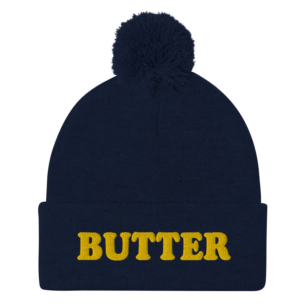 Navy Butter Beanie - Do you love butter? Looking for a funny gift for a butter enthusiast? This warm and cozy, embroidered beanie is just what you need. It's a classic pom pom beanie with "butter", expertly embroidered on the front. The perfect funny beanie for butter lovers and foodies of all kinds. Celebrate your favorite foods in our funky foodie apparel.