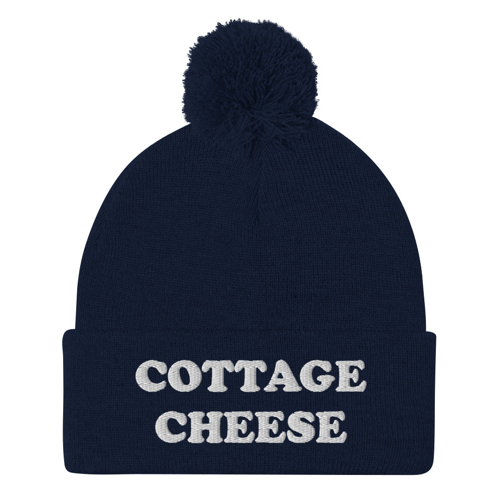 Navy cottage cheese beanie from Nina's Funky Shop - Do you love cottage cheese? Looking for a funny gift for a cottage cheese enthusiast? This warm and cozy, embroidered beanie is just what you need. It's a classic pom pom beanie with "cottage cheese", expertly embroidered on the front. The perfect funny beanie for everyday streetwear and foodies of all kinds.