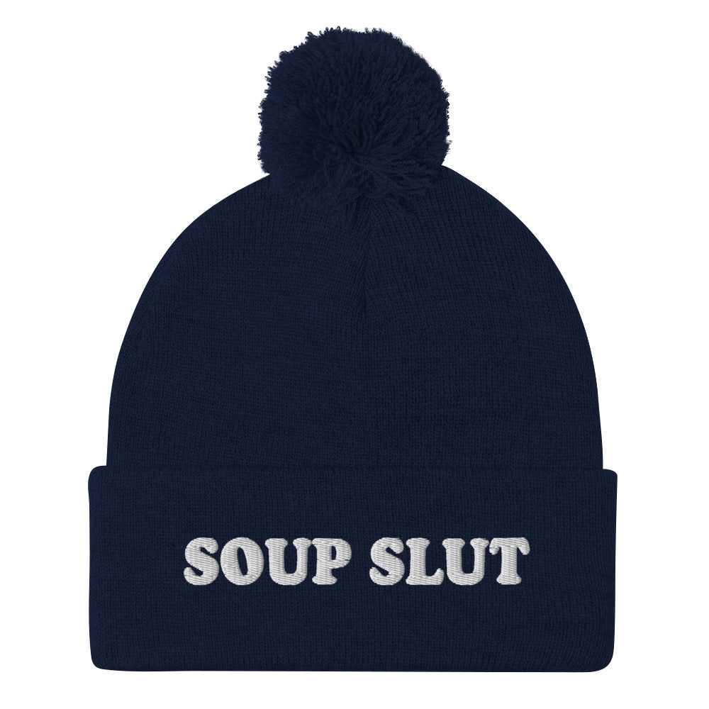 Navy Embroidered Beanie with Soup Slut from Nina's Funky Shop - Love soup? Looking for a funny gift for a soup enthusiast? This warm and cozy, embroidered beanie is just what you need. It's a classic pom pom beanie with "soup slut", expertly embroidered on the front. The perfect weird beanie hat for soup sluts and foodies of all kinds. Celebrate your favorite foods in our funky foodie apparel.