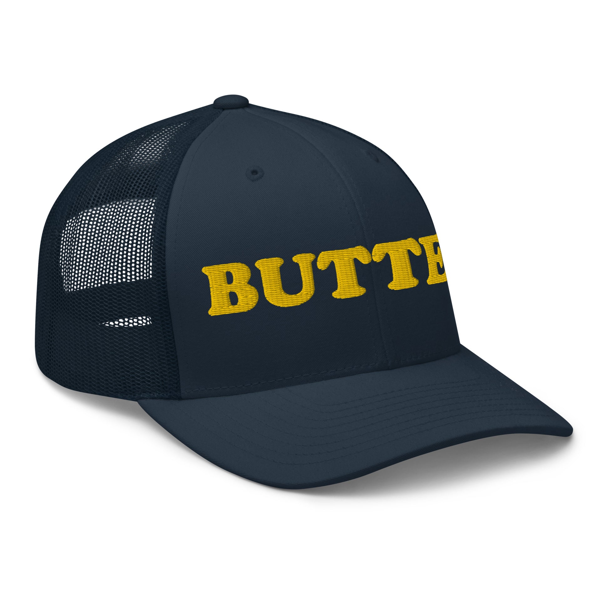 Navy trucker hat with "butter" embroidered on the front in yellow Are you a butter enthusiast? Looking for a funny gift? Our Butter Hat is comfortable and made just for you. It comes in a variety of colors with "butter", expertly embroidered on the front. Make a statement and eat your favorite buttery foods in our butter trucker hat.