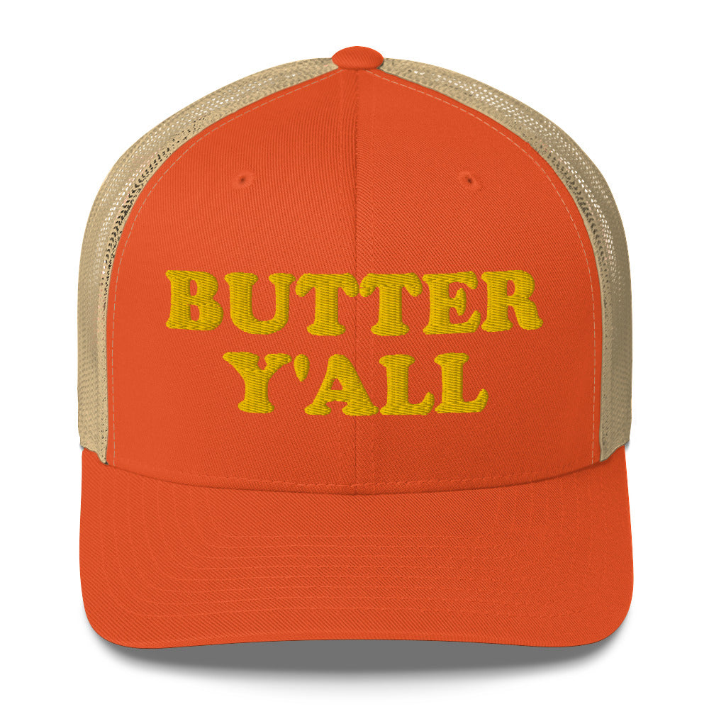 Orange and khaki Butter Hat - Are you a butter enthusiast? Looking for a funny gift? Our Butter Y'all Hat is comfortable and made just for you. It comes in a variety of colors with a funny butter phrase, expertly embroidered on the front. Make a statement and eat your favorite buttery foods in our butter y'all trucker hat.  Edit alt text