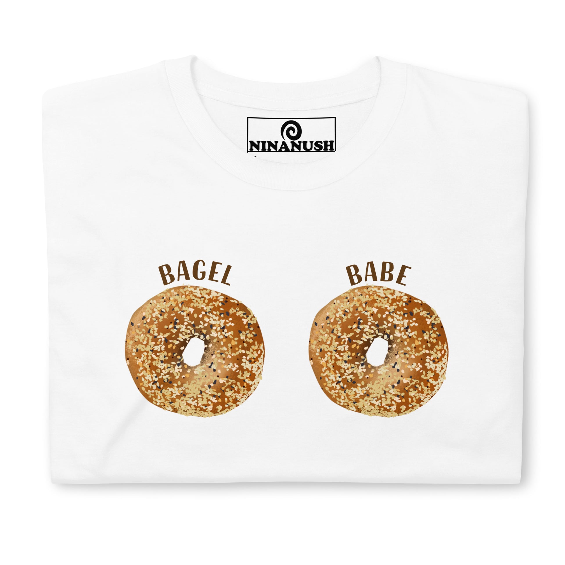 White everything bagel boobs shirt - Two everything bagels with the words "BAGEL BABE" printed on the breasts of a classic cotton tee. It's soft, comfortable and made just for you and your favorite bagel enthusiast. This funny bagel shirt is designed for bagel lovers and makes a quirky gift for foodies of all kinds. Eat bagels in this bagel boobs shirt.