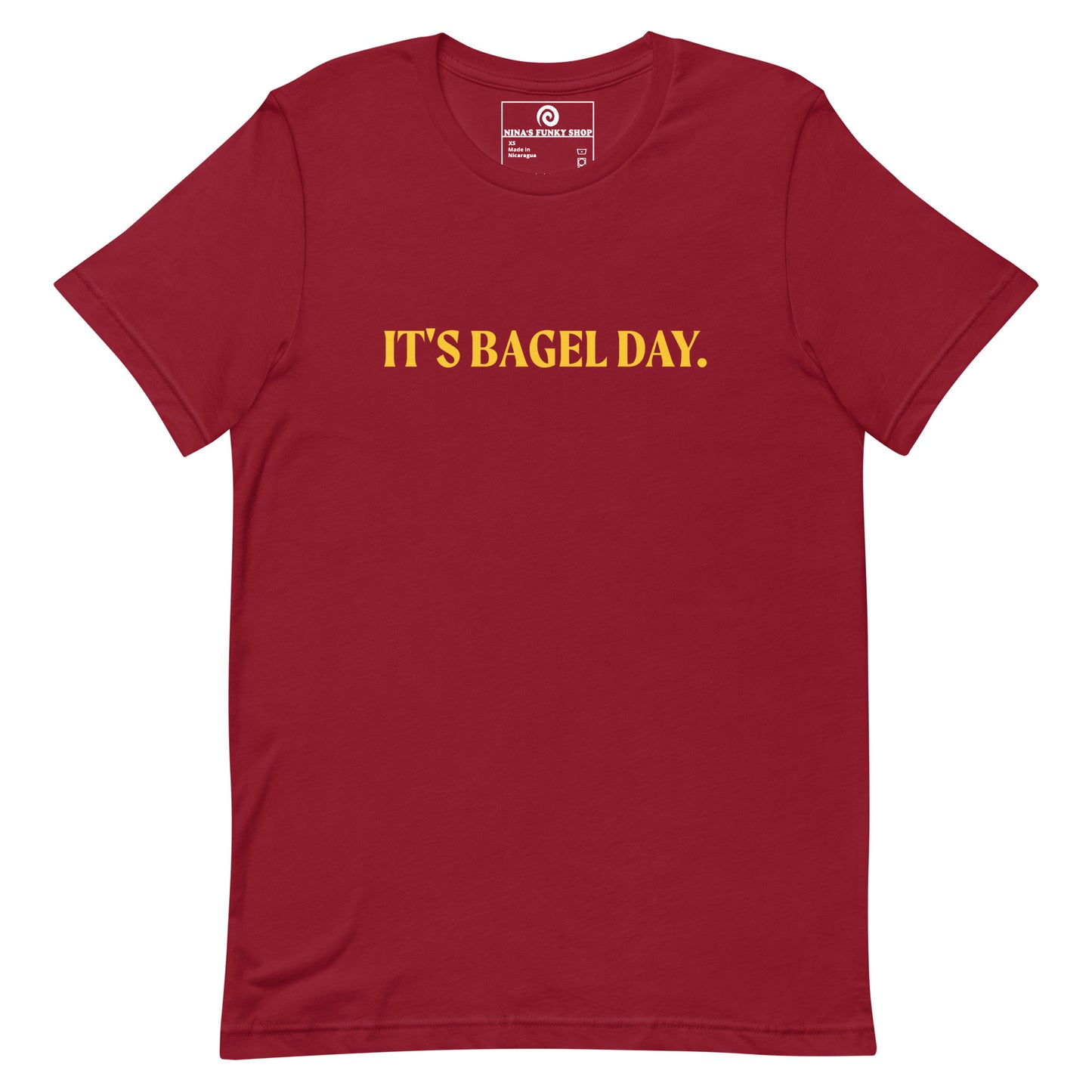 Red It's Bagel Day T-Shirt - Are you a bagel enthusiast? Looking for a funny gift for a fellow bagel lover? Every day is bagel day in our "It's Bagel Day T-shirt". It's a soft and comfortable, unisex t-shirt that comes in a variety of colors with a funny bagel saying, expertly printed on the front. Eat your favorite bagels and make a statement. Celebrate your favorite foods in our funky foodie apparel.