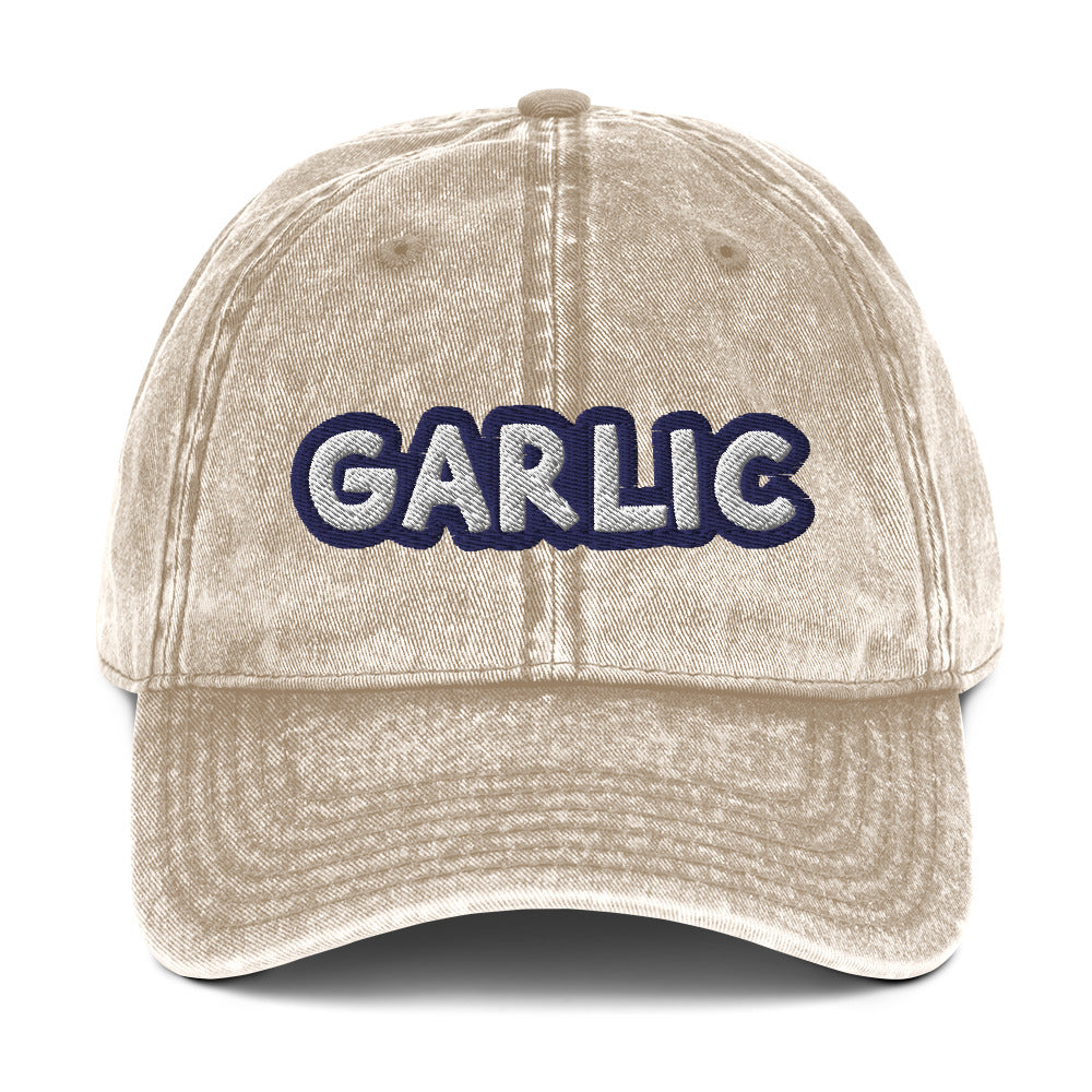 Tan garlic dad hat from Nina's Funky Shop by ninanush - If you're a garlic lover, this funny food hat was designed just for you. Eat garlic in style and make a statement in this stand out foodie dad hat. It's a garlic lover hat that's made of cotton, with a washed out vintage style and an eye-catching blue and white embroidery. Perfect for garlic enthusiasts and foodies of all kinds.