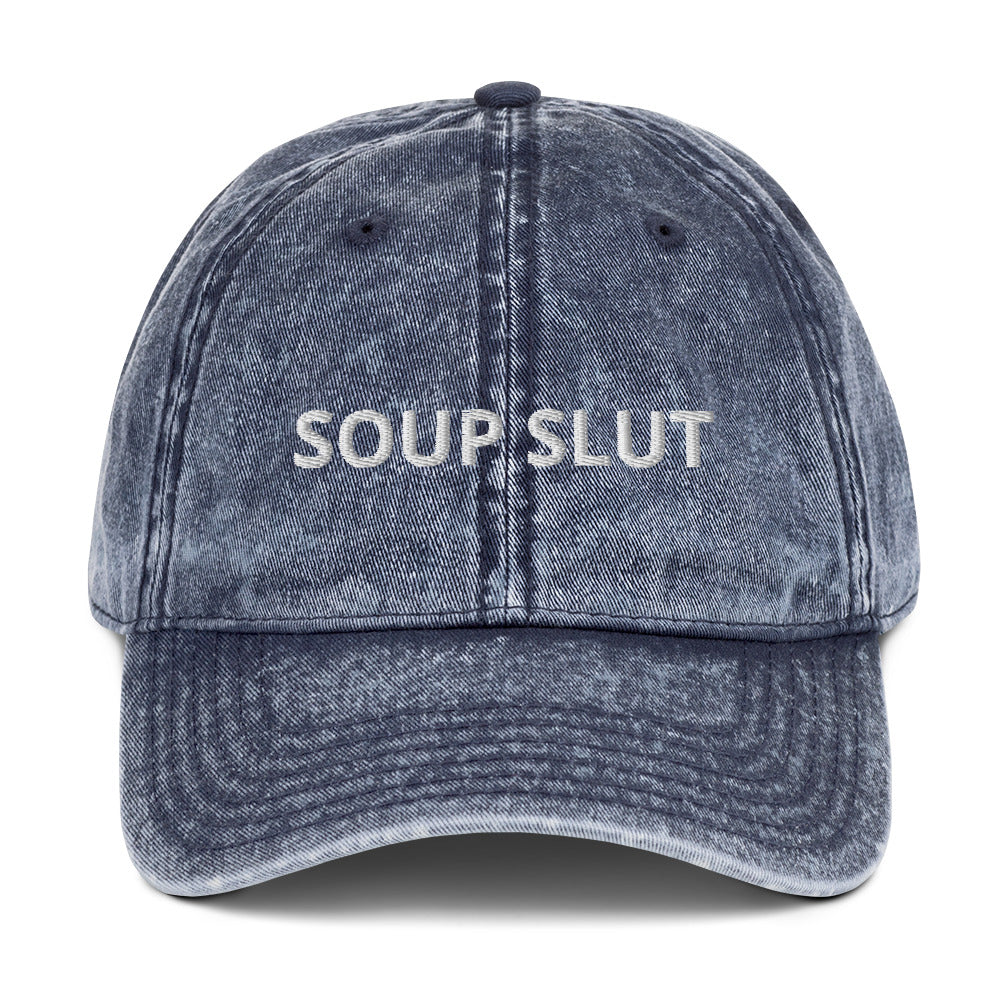 Navy soup slut dad hat - Are you a soup slut? Looking for a funny gift for a soup enthusiast? Our Soup Slut Hat is just what you need. It's comfortable, has an adjustable closure, and comes in a variety of colors with "Soup Slut", expertly embroidered on the front. Eat your favorite soups and add a little personality to your everyday style. Celebrate your favorite foods in our funky foodie clothing and accessories. 