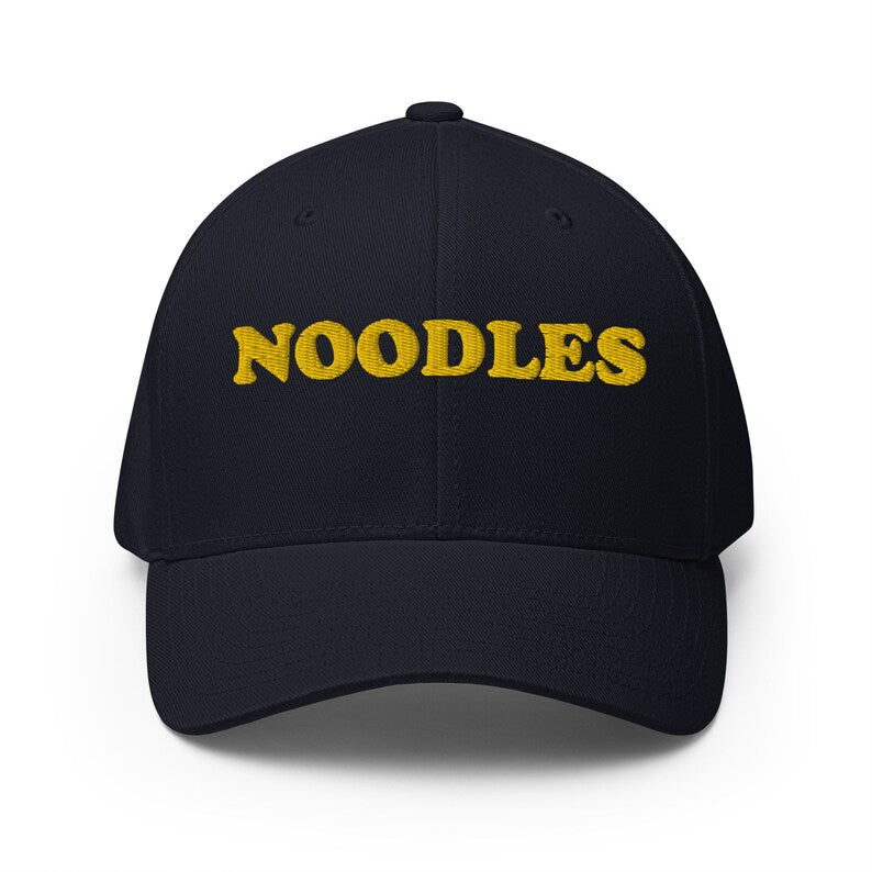 Dark Navy hat for making a statement about your favorite foods. - A funny statement hat for foodies and noodle lovers. It's a classic embroidered hat with the word noodles. This funny foodie hat is comfortable, unique and a perfect hat for noodle enthusiasts! Stay weird and eat noodles in this weird and unusual hat. It's a hat that's sure to get attention and maybe even noodles.