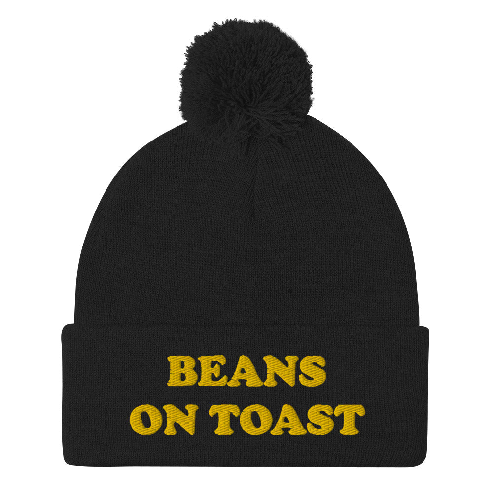 Black beans on toast beanie with pompom - This beans on toast beanie is a unique, warm & cozy hat. It's a classic beanie with a pompom and a funny food embroidery. Celebrate your favorite British foods in our funny food hats and weird food clothing. This beans on toast, British food beanie can be a funny gift for foodies or a weird hat for everyday streetwear.