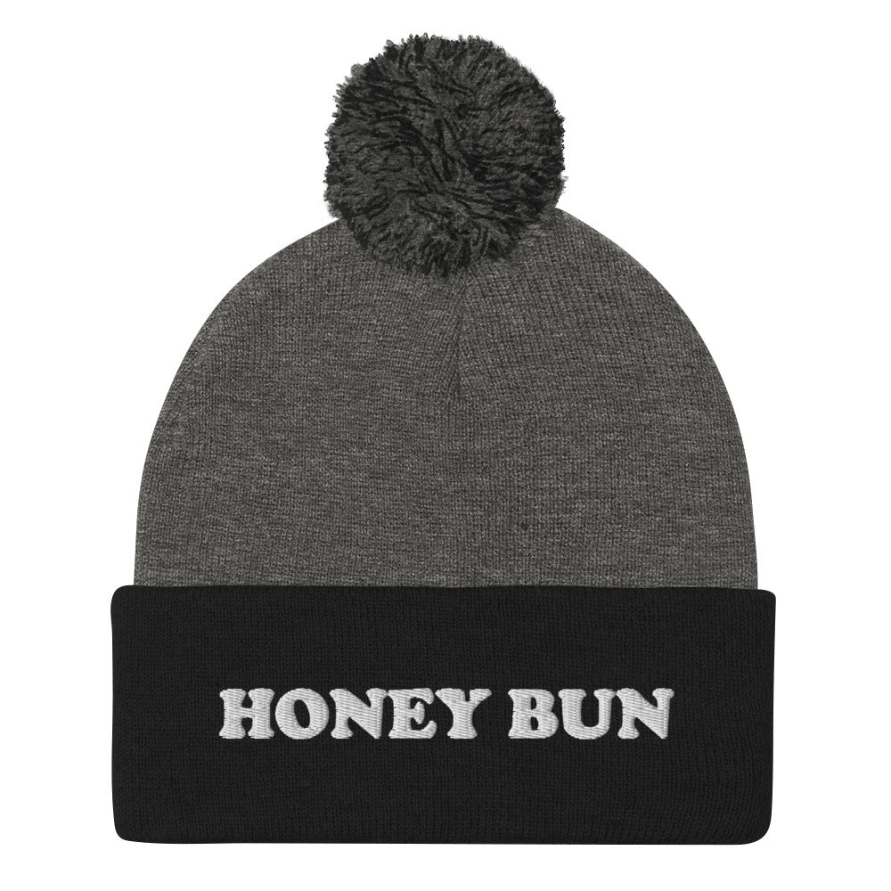 Black and gray honey bun beanie for foodies - Honey Bun Pom-Pom Beanie. This cute foodie beanie is a perfect warm and cozy hat for cold weather. It's a classic beanie with a pom pom on top and unique white embroidery. The funny honey bun hat is a weird foodie hat that's a perfect gift for foodies and honey bun lovers.  Stay warm in our funky foodie clothing.