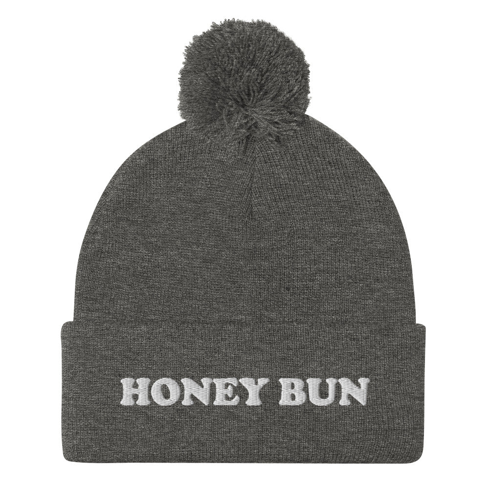 Cute gray honey bun hat for foodies - Honey Bun Pom-Pom Beanie. This cute foodie beanie is a perfect warm and cozy hat for cold weather. It's a classic beanie with a pom pom on top and unique white embroidery. The funny honey bun hat is a weird foodie hat that's a perfect gift for foodies and honey bun lovers.  Stay warm in our funky foodie clothing.