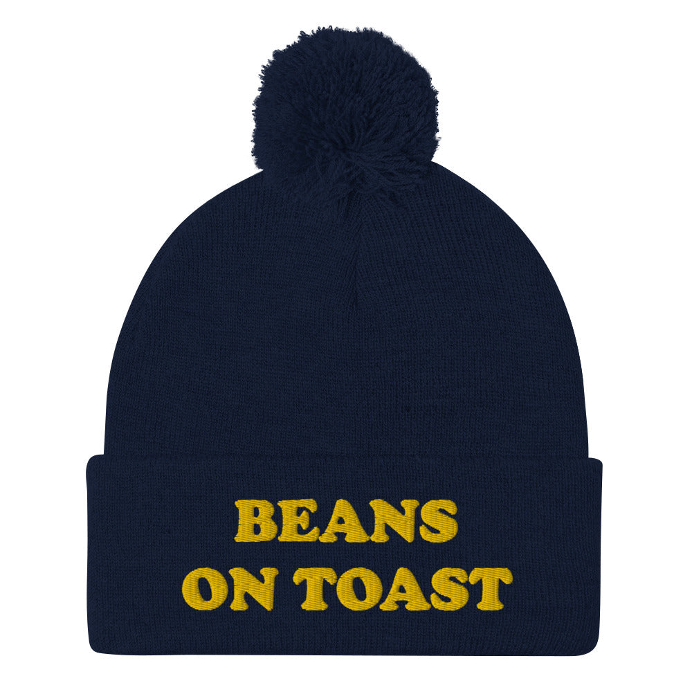 Navy blue beans on toast beanie with pompom - This beans on toast beanie is a unique, warm & cozy hat. It's a classic beanie with a pompom and a funny food embroidery. Celebrate your favorite British foods in our funny food hats and weird food clothing. This beans on toast, British food beanie can be a funny gift for foodies or a weird hat for everyday streetwear.